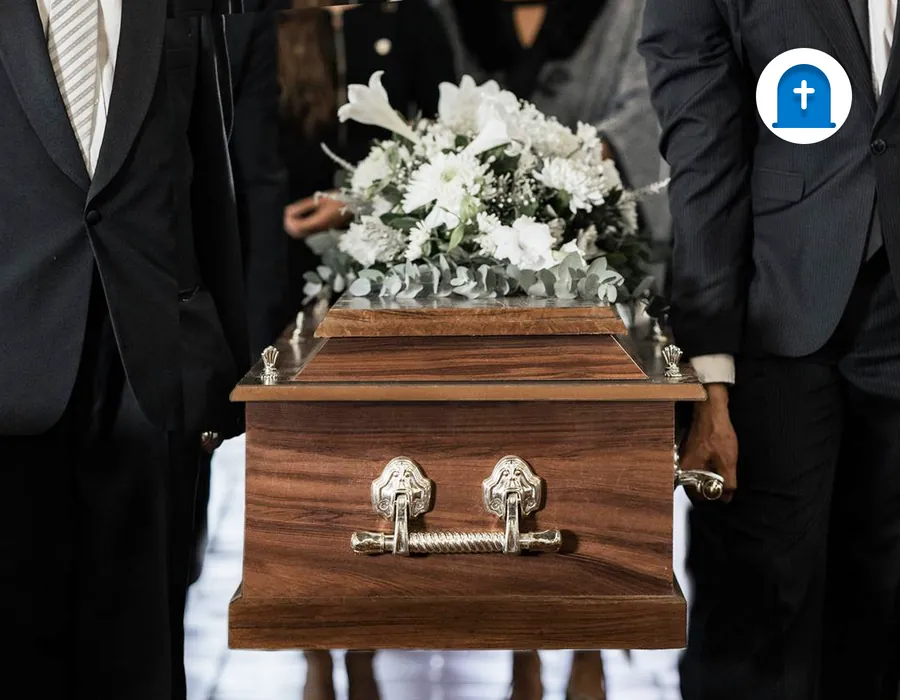 Pallbearers carrying a casket with white flowers