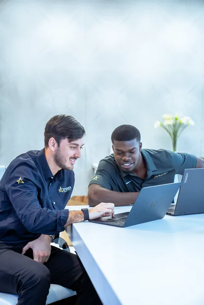 Two Astra team members reviewing campaign results on a laptop