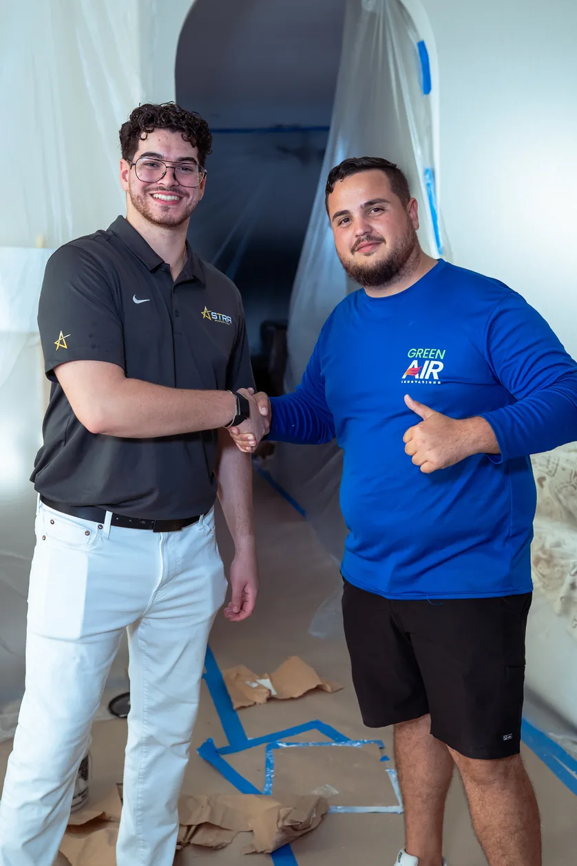 An Astra team member shaking hands with a Green Air Services agent